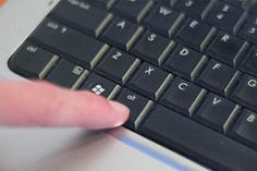 a close up of a person's finger on a computer keyboard with the keys turned off