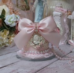 there is a small pink hat with pearls on it and a bow around the top