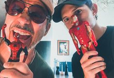 a man and woman are posing for the camera while they both have plastic toys in their mouths