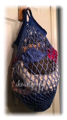 a blue net bag hanging from the side of a door with stuffed animals in it