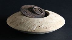 a wooden bowl with a lid sitting on a black surface