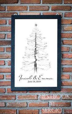 a black and white christmas tree on a brick wall in front of a framed photo