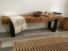 a wooden bench sitting on top of a floor next to a basket filled with books