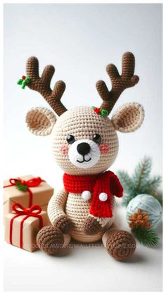 a crocheted stuffed animal with antlers on it's head sitting next to presents