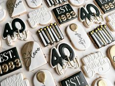 decorated cookies with black and white icing are arranged on a table in the shape of letters