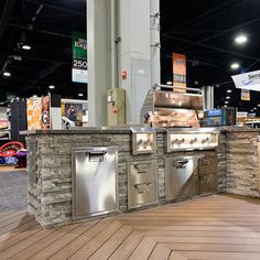 an outdoor kitchen is shown in the middle of a showroom with wood flooring