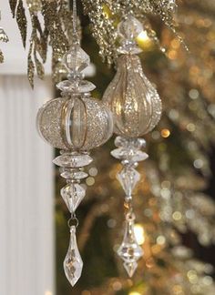 an ornament hanging from a christmas tree in front of a lite - up christmas tree