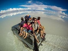 a group of people riding on the back of a boat in the middle of water