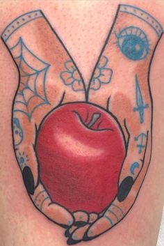 an apple in the shape of two hands with tattoos on it's arms and wrist