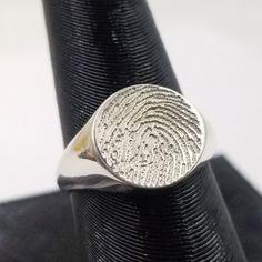 Our circle fingerprint memorial signet presents itself in a beautiful and simple design. These rings are individual cast and deeply engraved to insure the will wear for lifetimes. This classic design features a 10mm to 11mm for the largest ring size. These memorial items are not just jewelry, they are treasures. The listed price is for sterling silver. These can be cast in all golds 10k to 14k. If you would like a quote please ask. Your ring size will be needed to add up a quote for you. Custom Stamped Sterling Silver Signet Ring, Classic Hand Stamped Rings, Classic Engraved Signet Ring For Memorial, Classic Sterling Silver Hand Stamped Engraved Ring, Classic Engraved Ring For Memorial, Formal Etched Round Signet Ring, Minimalist Etched Round Ring, Engraved White Gold Round Ring, Etched Signet Ring For Promise