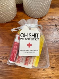 a package of toothpaste sits on a wooden table next to two white vases