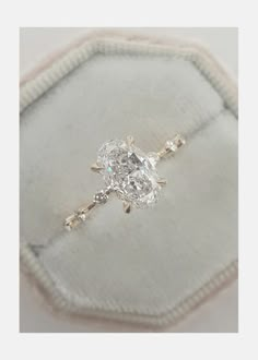 a diamond ring sitting on top of a cushion