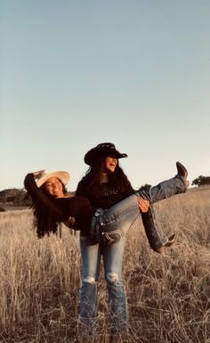 two women are standing in the middle of a field with their arms around each other