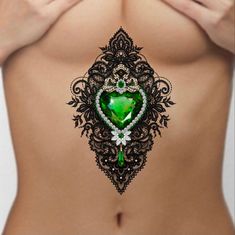 a woman's stomach with a green heart shaped brooch in the center, surrounded by jewels