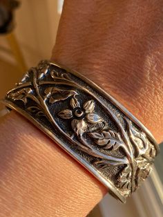 Slipada sterling silver retired Floral Vine Ornate Scroll Cuff bracelet Slipada retired sterling silver Clematic vine and leaves motif cuff bracelet in very nice pre-own condition.   Condition: very good as this is a pre-own item. Measures 2 .5" widest inside; open gap is about 1" inches open.   The band is about 1" inch tall. Total weight: 41.8  grams Bracelet is good for 7" to 7.5" wrist ( cuff can be slightly adjustable for better fitting due to sterling silver metal.) Hallmark: "925"  and Slipada hallmark inside side band's edge. The video and photos shown here are the actual items' pictures; please refer the video and all pictures to see the actual item's condition.  (Please do note that vintage items might sometimes might have that special age natural patina look due to they are old. Unique Antique Silver Cuff Bracelet With Intricate Design, Silver Bohemian Cuff Bracelet With Patina, Handmade Sterling Silver Ornate Cuff Bracelet, Antique Silver Filigree Cuff Bracelet, Vintage Sterling Silver Cuff Bracelet With Patina, Patina Jewelry, Cameo Brooch, Wrist Cuffs, Sterling Silver Cuff Bracelet