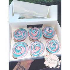 cupcakes with pink and blue frosting in a box