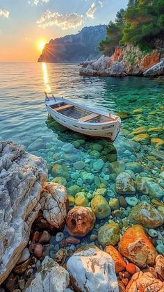 there is a boat that is sitting in the water near rocks and stones on the shore