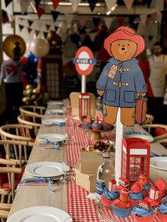 there is a table set up with red, white and blue decorations for a teddy bear themed birthday party