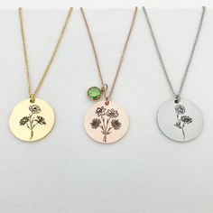 three different necklaces with flowers on them