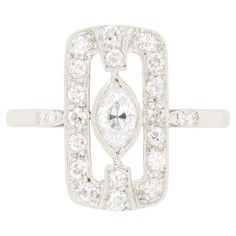 This striking Art Deco Diamond Cluster Ring showcases a 0.40 carat old marquise cut diamond at it’s centre. Rub over set, the diamond boasts a colour of F and clarity of VS1. Surrounding the centre stone is a rectangular halo of eight cut diamonds, totalling 0.38 carats. These surrounding diamonds match the centre in quality. Crafted entirely in platinum, this ring embodies the classic geometrical design and elegance that define the Art Deco era. Gemstone: Diamond Stone Shape: Marquise Cut Carat Weight: 0.40 Colour: F Clarity: VS1 Metal: Platinum Age: 1920s Size: M Geometrical Design, Shopping Photography, Marquise Cut Diamond, 1920s Art Deco, Modern Art Deco, Art Deco Diamond, Art Deco Era, Diamond Cluster Ring, Marquise Cut