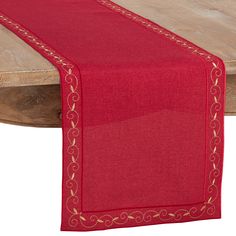 a red table runner on top of a wooden table