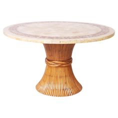 a round table with an intricate design on the top and base, made out of wicker