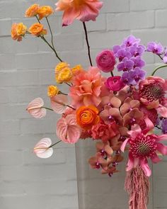 a vase filled with lots of different colored flowers