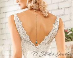 the back of a woman's wedding dress with an open neckline and beaded details