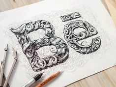 the number 50 is made up of intricately designed letters and swirls, along with two crayons