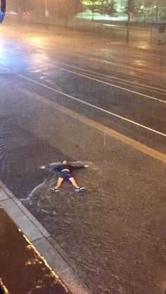 a man standing in the middle of a flooded street