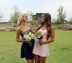 two beautiful young women standing next to each other holding bouquets in their hands and smiling