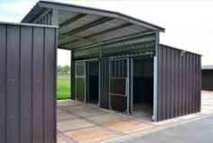 an empty metal building with open doors on the front and back sides, in a parking lot