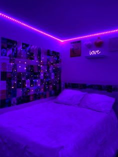 a bedroom with purple lighting and pictures on the wall