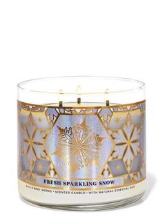 a candle that is sitting on top of a white surface with the words fresh sparkling snow written