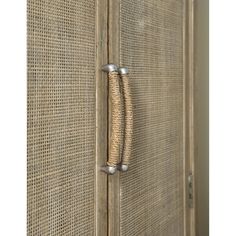 a close up of a door handle on an old wooden door with woven panels and metal handles