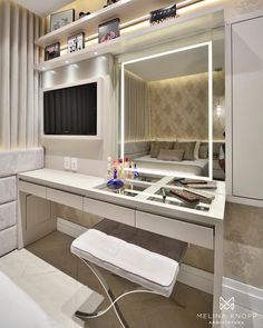 a bathroom with a sink, mirror and bathtub next to a wall mounted tv