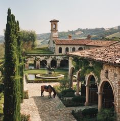 a horse is standing in front of a building with an arched doorway and stone walkway