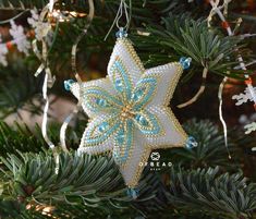 a christmas ornament hanging from a tree with blue and white decorations on it