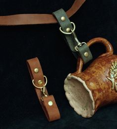 a brown leather strap with a tea pot on it and a keychain attached to it