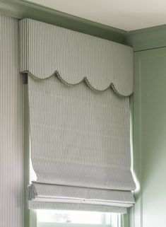 a kitchen with green walls and white blinds