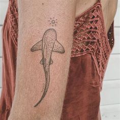 a person with a tattoo on their arm that has a whale in it's back