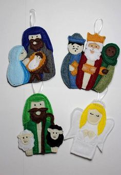 three christmas ornament hangings with nativity images on them, one in the shape of an angel