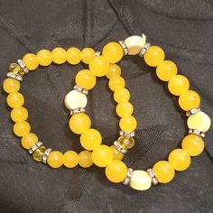 Elastic Stretches To Fit Most Any Wrist. Two Pretty Yellow Beaded Bracelets With Metal Bead Separators With Cz's. One Bracelet Has 4 Light Yellow Flat Round Bead Accents And The Other Has Four Faceted Yellow Sparkly Bead Accents. Great Summer Color! Stones Are Possibly Yellow Agate Or Yellow Jade Semi Precious Stones, Not Sure Which. One Bracelet The Stones Are Larger Than The Other. Handmade Handcrafted Hand Made Hand-Made Artisan #1 Yellow Bead Bracelet Ideas, Handmade Trendy Yellow Bracelets, Trendy Handmade Yellow Bracelets, Elegant Yellow Adjustable Beaded Bracelets, Elegant Yellow Stretch Bracelet With Round Beads, Yellow Casual Bracelet Jewelry, Elegant Yellow Beaded Stretch Bracelet, Casual Yellow Bracelet Jewelry, Elegant Yellow Stretch Bracelet