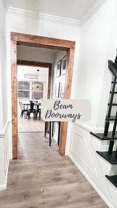 an open door leading to a dining room and living room area with stairs that lead up to the second floor