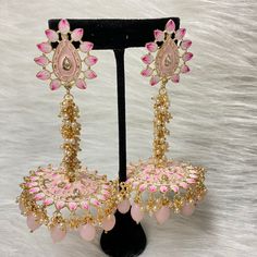 The exquisite and unique Baby Pink Nashira Jhumka are the perfect jhumkas for both party wear. This beautiful drop jhumka features dangling pearls, Baby Pink beads, Hand-painted Meenakari, and high-quality kundan on Gold-Plating. Specifications Materials used: Baby Pink Beads, Meenakari, pearls, gold plating Length: 10 cm Weight: 38 grams At Romikas, we pride ourselves on the craftsmanship and high quality of our jewelry, designed to enhance your natural beauty. Please contact us with any questi Festive Bridal Earrings With Meenakari, Traditional Meenakari Dangle Jhumkas, Traditional Pink Tikka For Celebration, Pink Festive Tikka, Party Kundan Jhumkas In Temple Jewelry Style, Kundan Jhumkas For Party, Temple Jewelry Style, Kundan Temple Jewelry Jhumkas For Party, Temple Jewelry Kundan Jhumkas For Party, Temple Jewelry Meenakari Jhumkas For Festivals