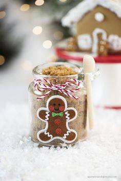 a jar filled with gingerbread cookies next to a christmas tree