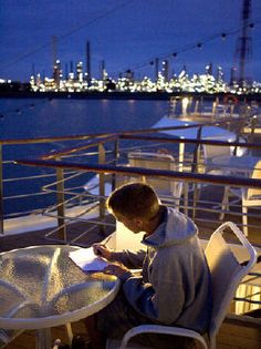 a man sitting at a table on top of a boat