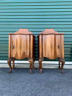 two wooden nightstands sitting next to each other in front of a green garage door