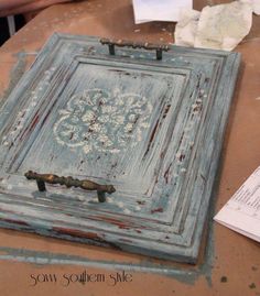 an old wooden box sitting on top of a table next to some papers and scissors