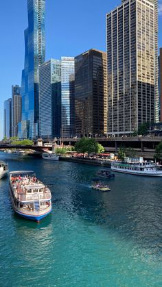 a boat traveling down the river in front of some tall buildings and other large skyscrapers